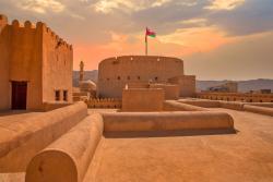 Pevnosť Nizwa s ománskou vlajkou. Omán. Foto: adobe.com