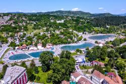 Bazény, zelené kopce a budovy v meste Tuzla. Bosna a Hercegovina.