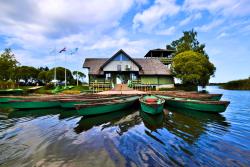 Národný park Gauja, s loďami a domom. Lotyšsko. Foto: unsplash.com