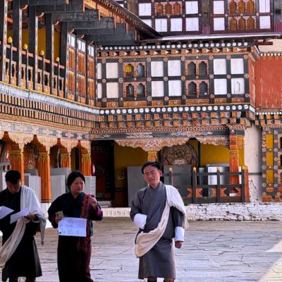 Bhutánska architektúra a miestni obyvatelia v tradičnom odeve. Bhután