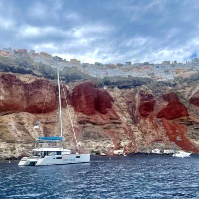 Pohľad z lode na mesto Oia a červený sopečný útes. Santorini.