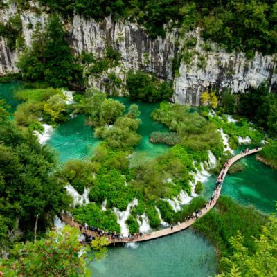 Plitvické jazerá a drevený chodník a kráčajúci turisti. Chorvátsko.