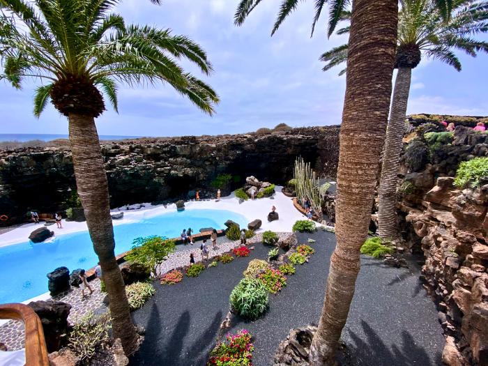 Jameos del Agua s bazénom, palmami a lávovými stenami. Lanzarote. Foto: unsplash.com