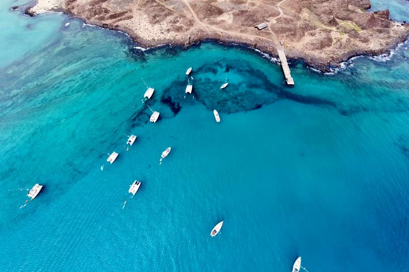 Tyrkysový oceán a  biele lode na drsnom pobreží Lanzarote. Kanárske ostrovy. Foto: unsplash.com