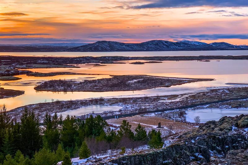 Stromy, more a kopce posiate snehom pri západe slnka v NP Tingvellir, Island. Foto: unsplash.com