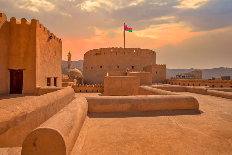 Pevnosť Nizwa s ománskou vlajkou. Omán. Foto: adobe.com