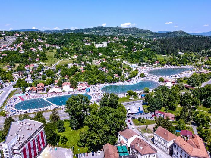 Bazény, zelené kopce a budovy v meste Tuzla. Bosna a Hercegovina.