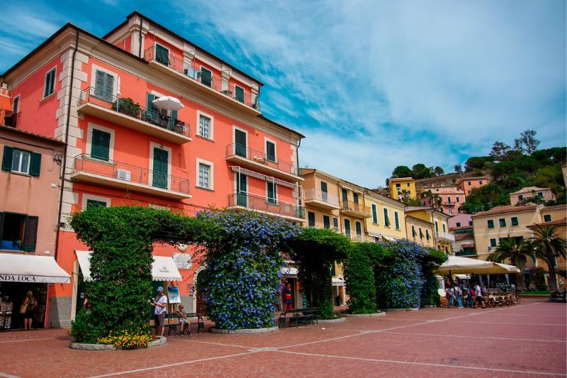 Farebné námestie - budovy a zelené kvety v Porto Azzuro, Taliansko. Foto: unsplash.com