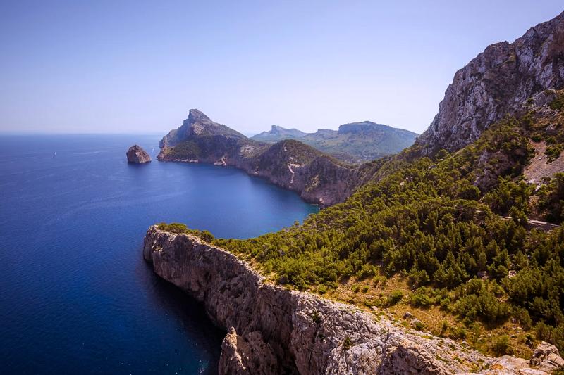 Skalné pobrežie pokryté zelenými stromami v Cap de Formentor, Malorka. Foto: unsplash.com