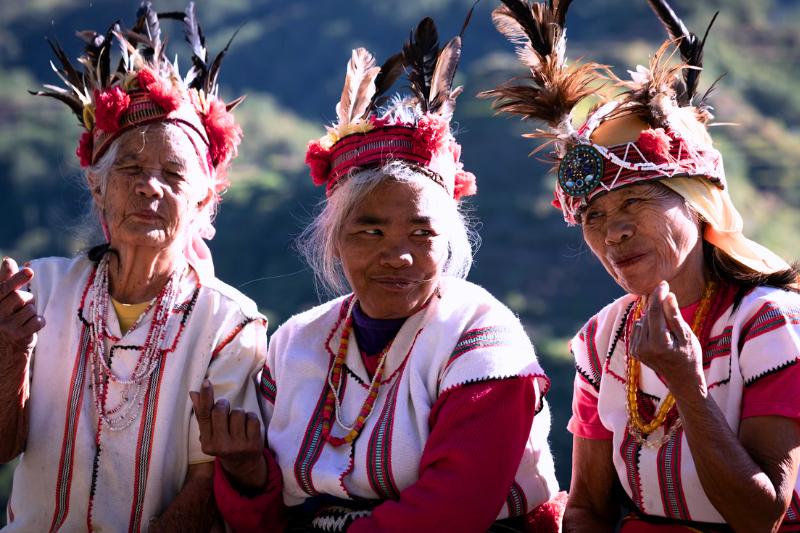 Tri Filipínky odeté do červenobielych krojov. Ifugao. Filipíny. Foto: unsplsh.com