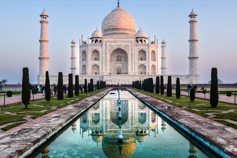 Biela mramorová stavba s kupolami, vežami, záhradou a bazénom. Tádž Mahal, India