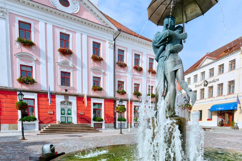 Tartu, historická budova a fontána so sochami. Estónsko. Foto: unsplash.com