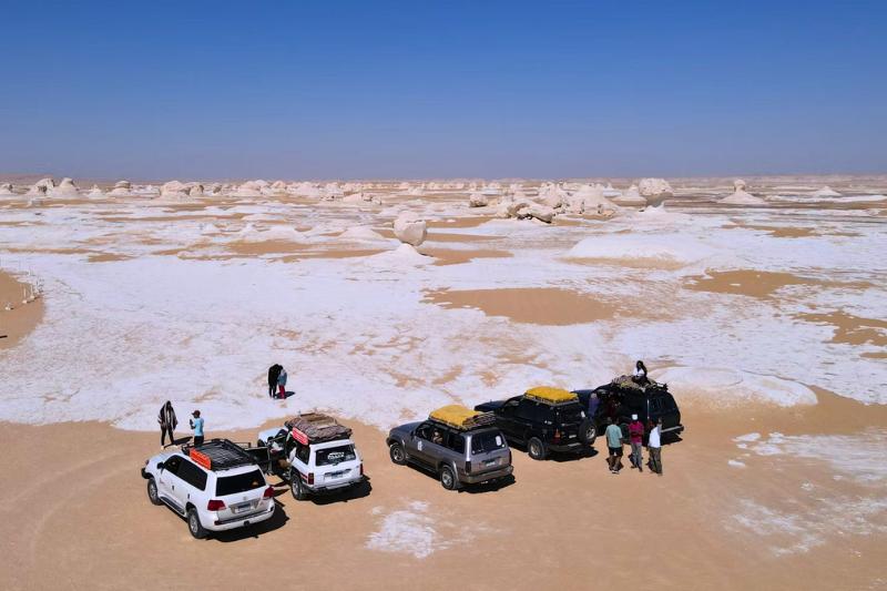 Biela púšť v kontraste s pieskovými dunami a džípmi. Egypt. Foto: unsplash.com
