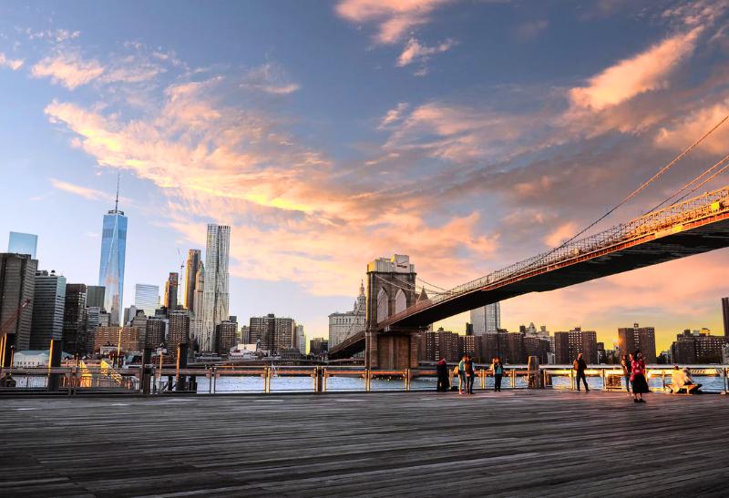 Most Brooklyn Bridge nad vodou a mrakodrapy. New York.