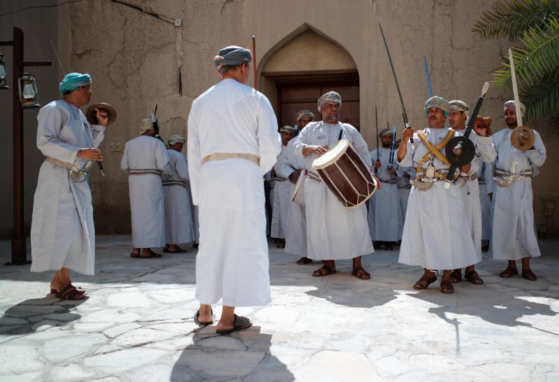 Hudobníci odetí v bielom v pevnosti Nizwa. Omán.