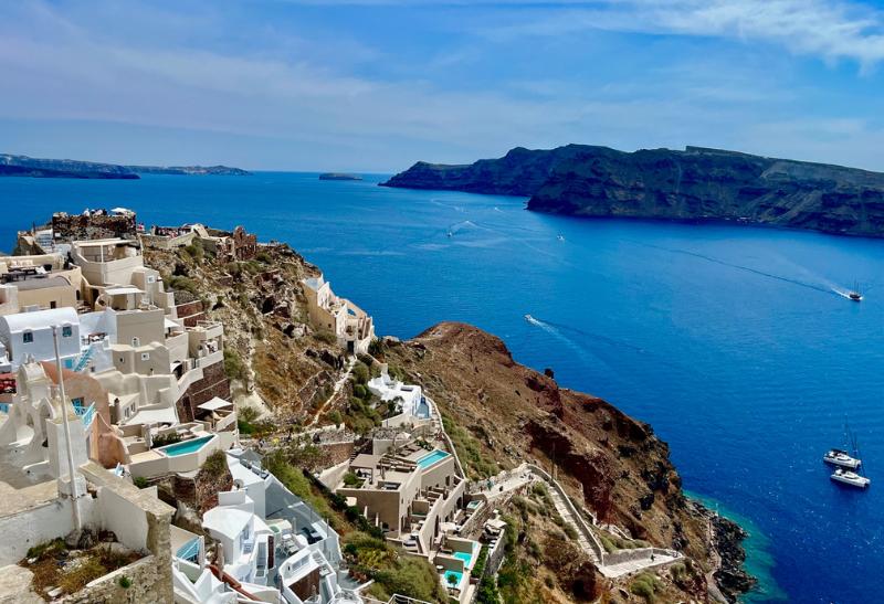 Biele domčeky mestečka Oia, útes, schody a okolité sopečné ostrovy. Santorini