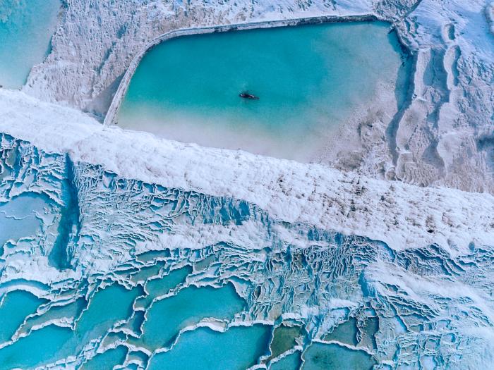 Pamukkale - tyrkysovo sfarbená voda v bielych prírodných bazénoch. Turecko.