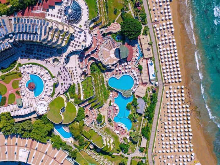 Pohľad z výšky na pieskovú pláž, bazény a hotel Sunrise Qeen. Turecko