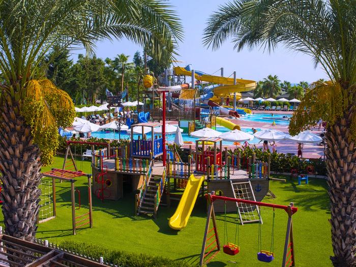 Aquapark,farebné tobogány a bazén a hracia loď na ihrisku hotela Turan. Turecko