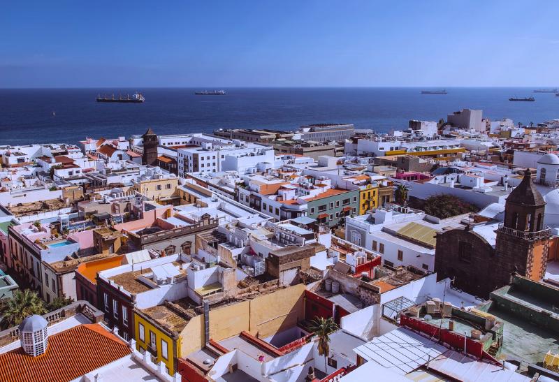 Mesto Las Palmas - strechy domov a oceán a lode v pozadí.