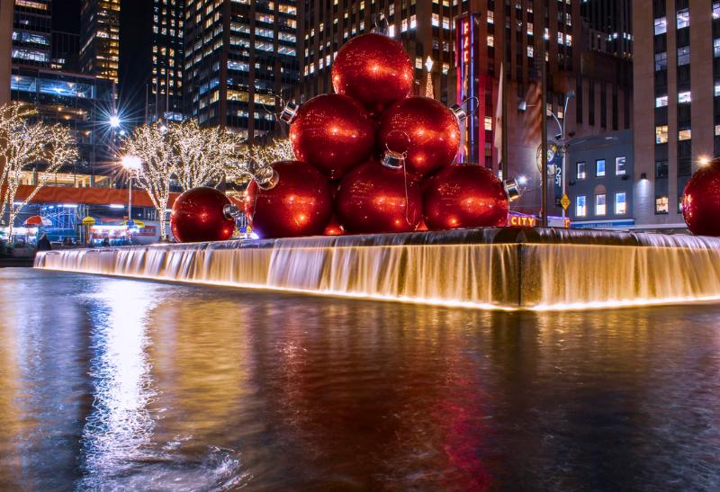 Vianočné červené gule na vode a okolité vysvietené mrakodrapy. New York.