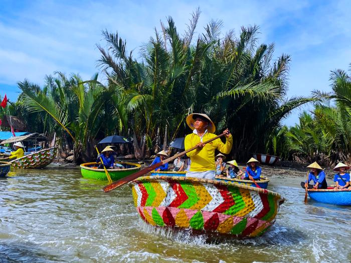 Farebné loďky a veslujúci Vietnamci.