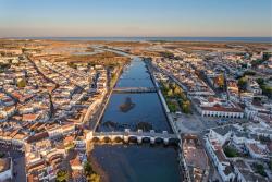 Historická Tavira na brehoch rieky a oceán v pozadí. Portugalsko.